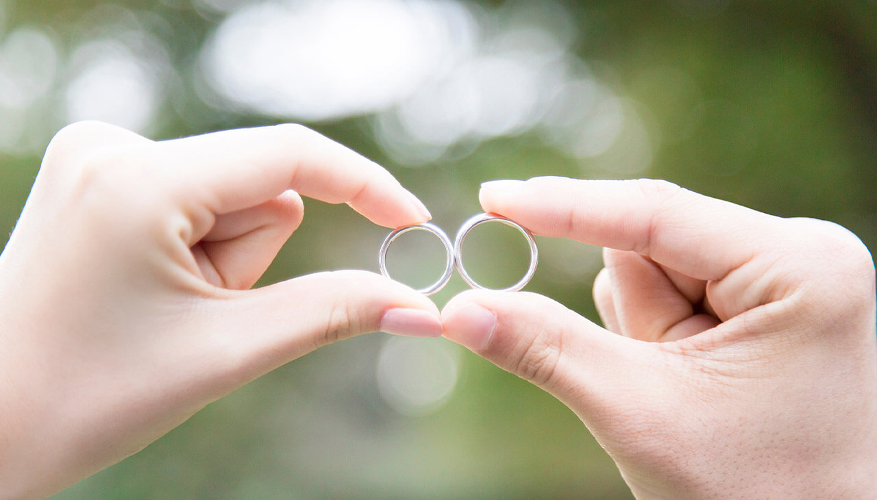 結婚指輪を持っているカップル