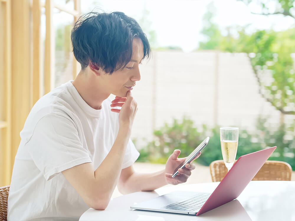 スマホとPCを操作してる男性