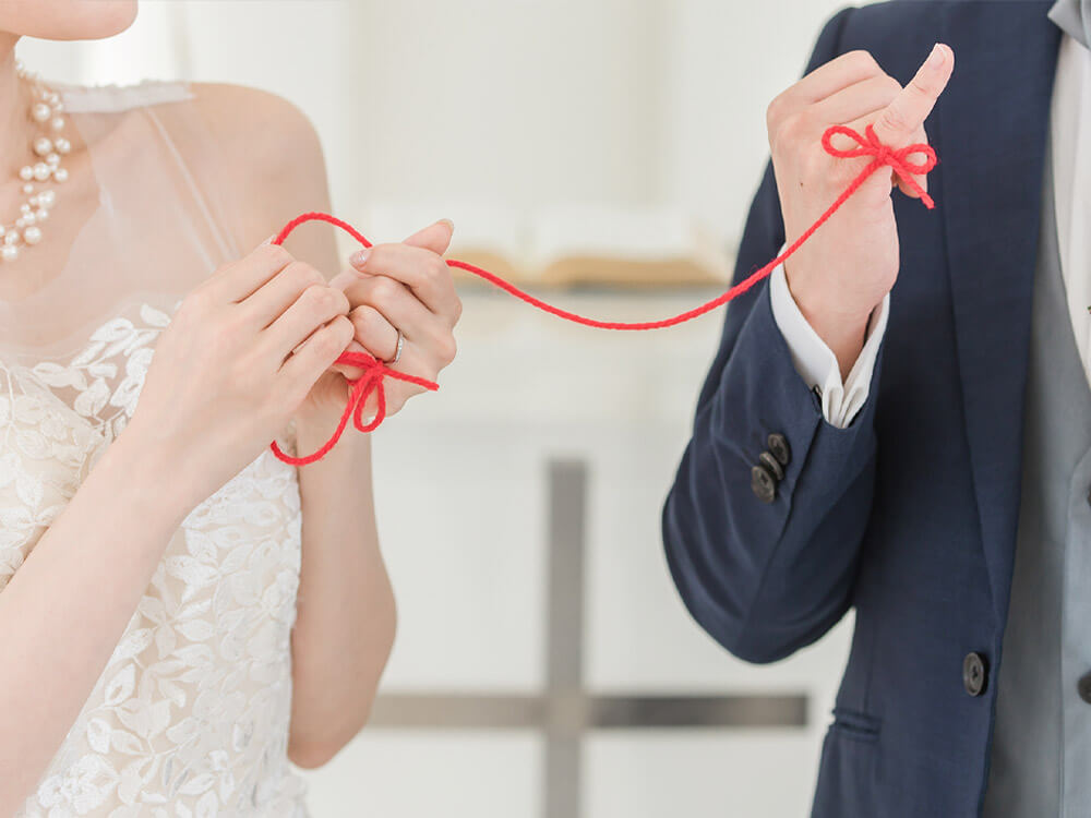 赤い糸で結ばれた新郎新婦